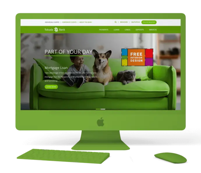 A green desktop computer displaying the Tokuda Bank homepage, featuring a promotional banner for a Mortgage Loan and Free Interior Design, with an image of a child, a Corgi dog, and a cat sitting on a bright green couch.